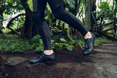 a woman running through the terrain in zero-drop shoes