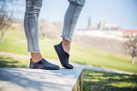 A woman in barefoot slip-on sneakers